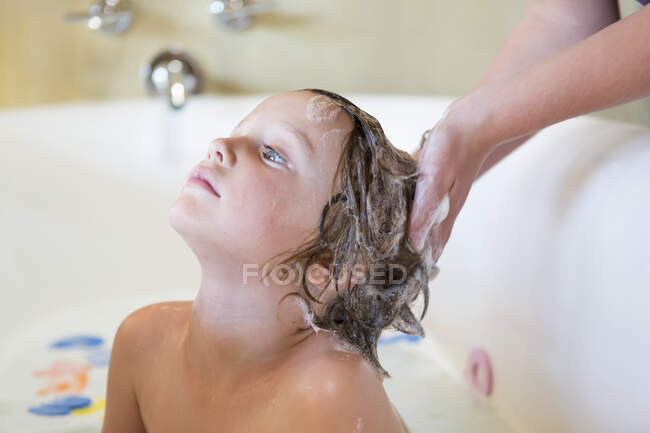 Menino de 4 anos tomando banho e xampu na banheira — Fotografia de Stock