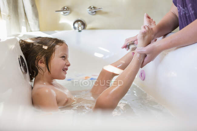 Menino de 4 anos tomando banho e xampu na banheira — Fotografia de Stock