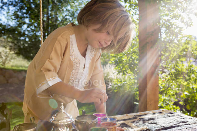 Niño de 4 años usando agua de colores para huevos, Pascua - foto de stock