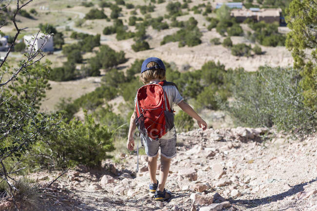 4 anni ragazzo escursioni nel paesaggio rurale, Lamy, NM. — Foto stock