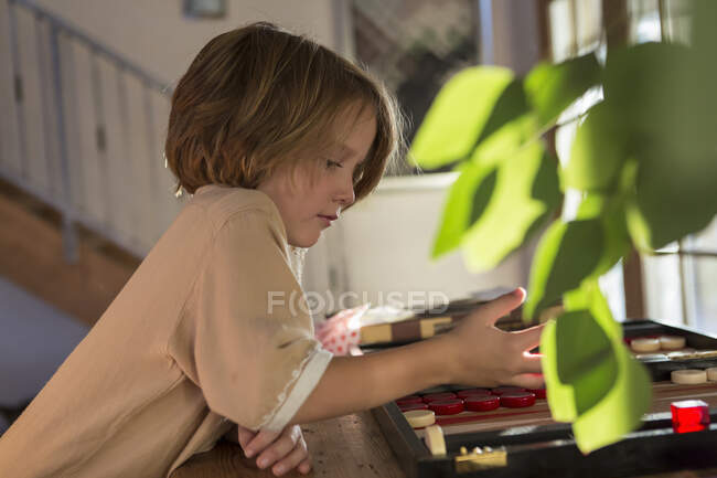 Menino de 4 anos jogando jogo de tabuleiro em casa — Fotografia de Stock