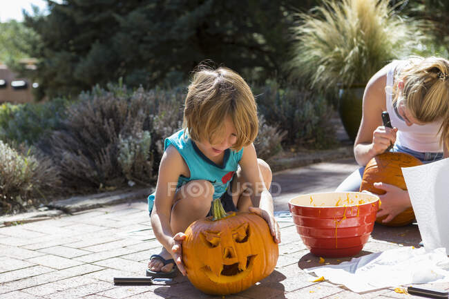 Young boy and his sister carving pumpkins — Stock Photo
