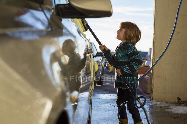 Vierjähriger Junge wäscht Auto in Waschanlage — Stockfoto