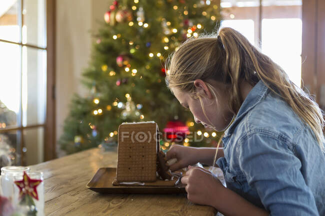 11-jähriges Mädchen baut zu Hause ein Lebkuchenhaus — Stockfoto