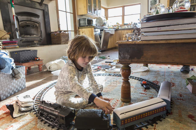 4-летний мальчик в пижаме играет с игрушками дома — стоковое фото