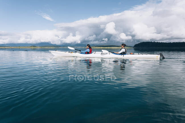 Kayak da mare che remano nelle acque incontaminate di una insenatura sulla costa dell'Alaska. — Foto stock
