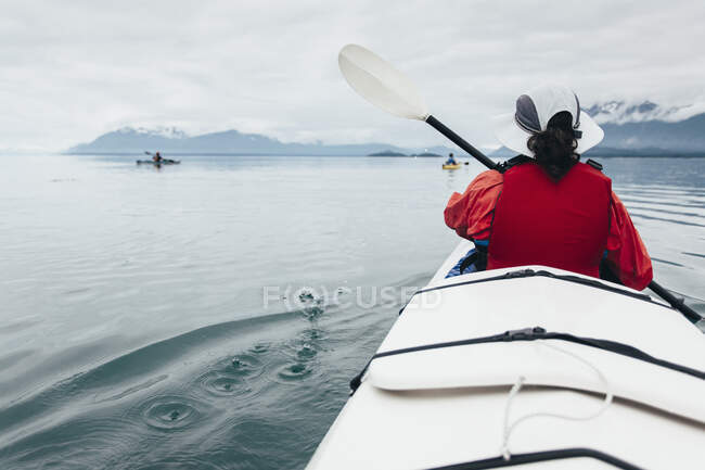 A small group of sea kayakers paddle pristine waters of Muir Inlet in Glacier Bay National Park, Alaska — Stock Photo