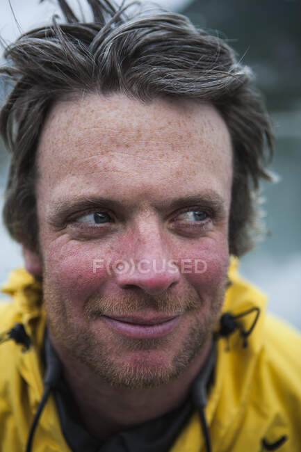 Portrait of smiling middle aged man in a yellow jacket outdoors — Stock Photo