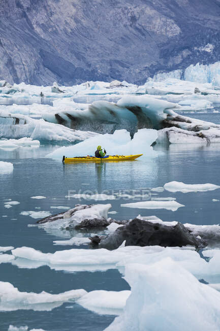 Kayak de mar remando en laguna glaciar en un extremo glaciar en la costa de Alaska - foto de stock