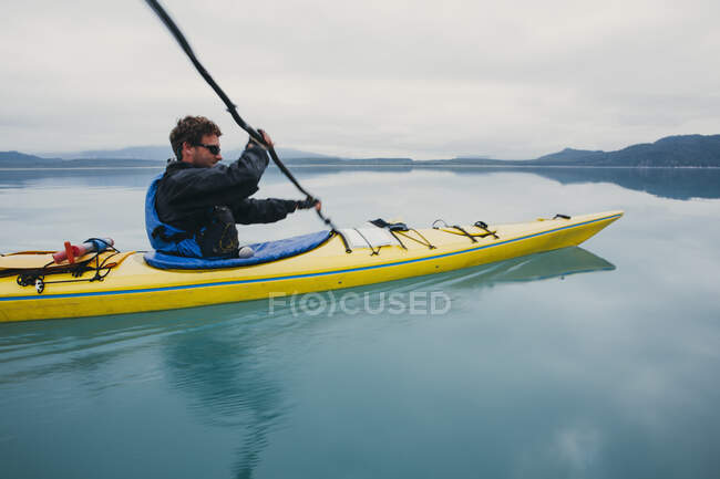 Man sea kayaking inan inlet on the Alaska coastline. — Stock Photo