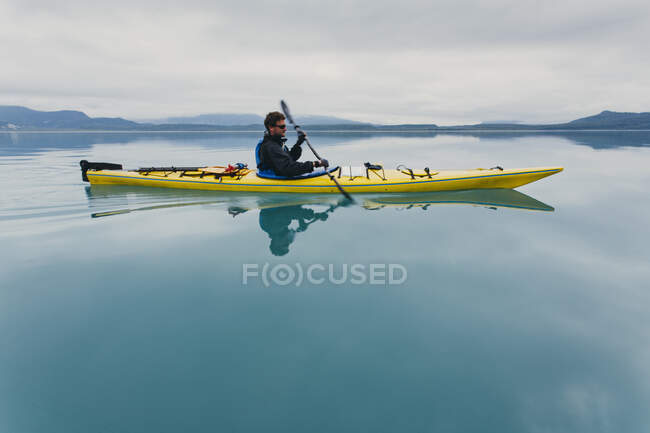 Man sea kayaking inan inlet on the Alaska coastline. — Stock Photo
