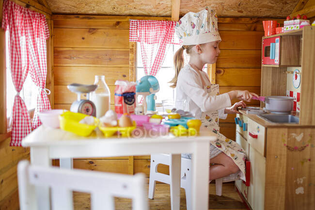Молода дівчина в Венді будинку прикидається приготуванням на кухні — стокове фото