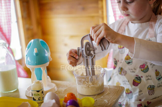 Jovem na casa de Wendy usando batedor de brinquedo fingindo cozinhar na cozinha — Fotografia de Stock