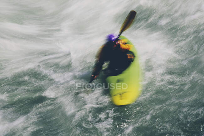 Whitewater kayaker paddling large river rapids on a fast flowing river — Stock Photo