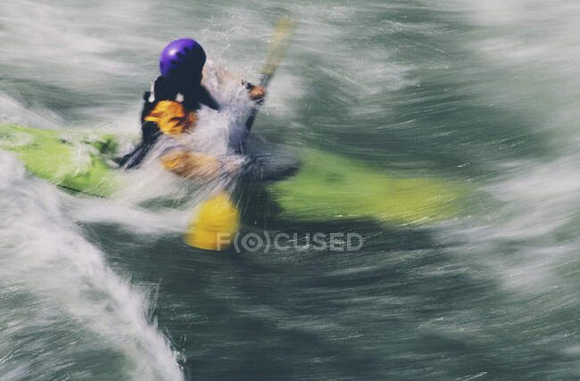 Wildwasser-Kajakfahrer paddelt große Stromschnellen auf einem schnell fließenden Fluss — Stockfoto