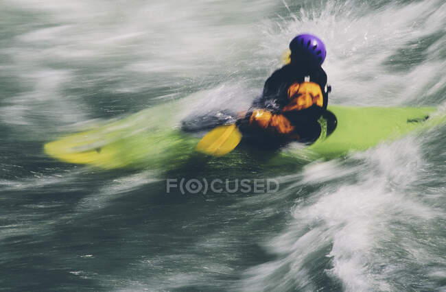 Kayak de aguas bravas remando grandes rápidos en un río que fluye rápido - foto de stock