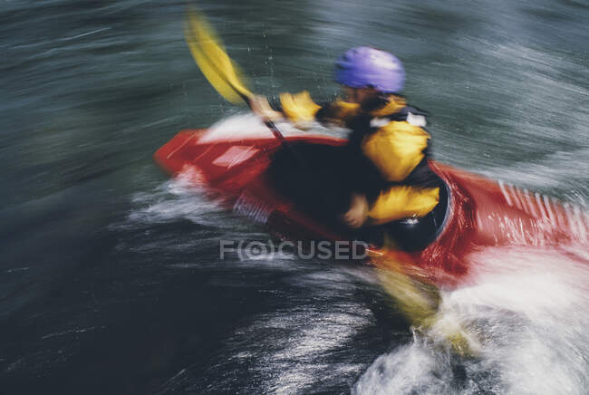 Weibliche Wildwasser-Kajakfahrerinnen paddeln Stromschnellen und surfen auf einem schnell fließenden Fluss. — Stockfoto