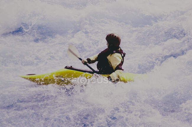 Image infrarouge couleur du kayakiste blanc pagayant sur les rapides d'une rivière qui coule rapidement. — Photo de stock