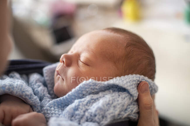 Testa di bambino addormentato tenuto in mano — Foto stock
