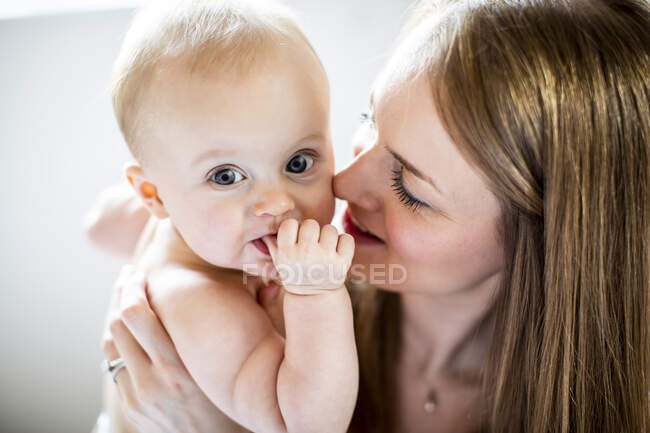 Porträt eines Babys, das von einer Frau in die Kamera gehalten wird — Stockfoto