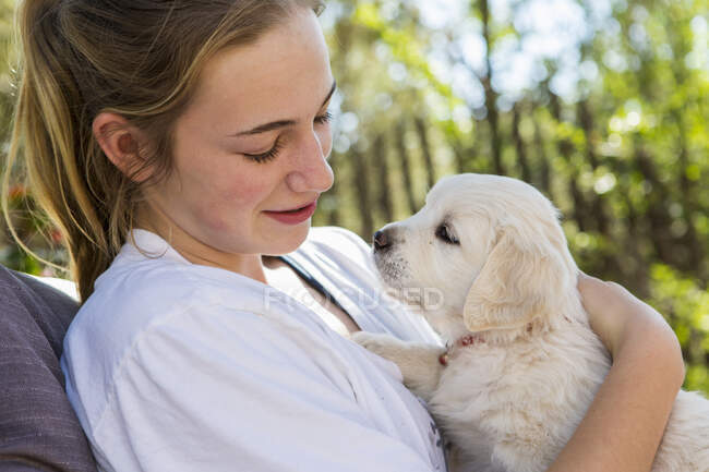 Adolescente ragazza in possesso di golden retriever cucciolo — Foto stock