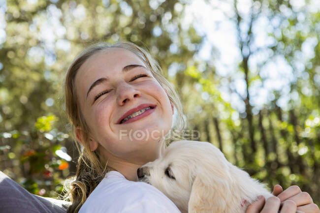 Teenager Mädchen hält Golden Retriever Welpen — Stockfoto