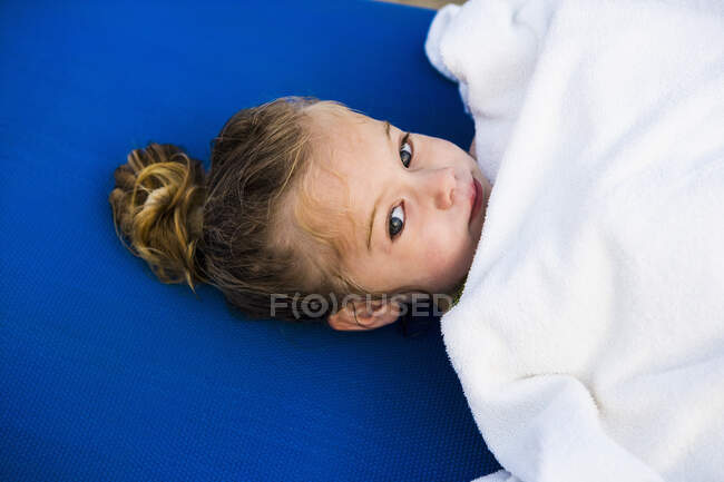 Portrait of 3 year old girl wrapped in white towel — Stock Photo