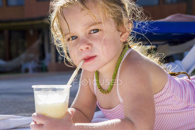 Portrait of 3 year old girl sipping a drink — Stock Photo