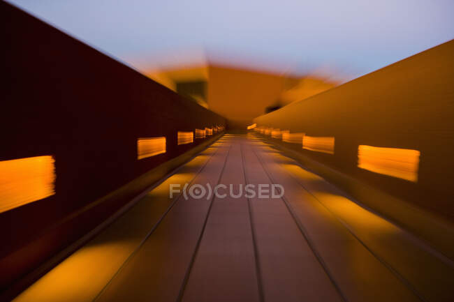 Motion blur, una passerella colorata con balaustra e macchie di luce solare. — Foto stock