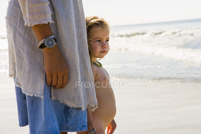 Retrato de niña de 3 años con madre en la playa - foto de stock