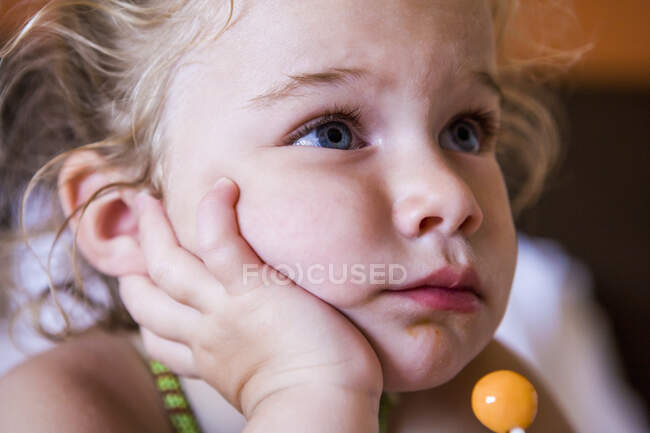 Portrait of 3 year old girl with a lollipop — Stock Photo