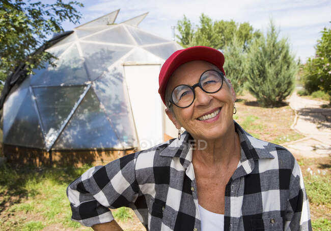 Mulher sênior jardinagem em cúpula geodésica, Santa Fe, NM. — Fotografia de Stock