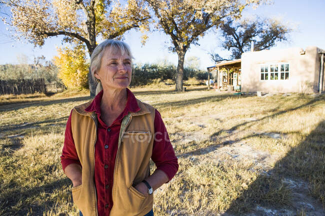 Mujer madura en casa en su propiedad en un entorno rural - foto de stock