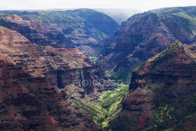 Vista elevata di profondi canyon, verdi valli fertili e ripide vette di un paesaggio insulare — Foto stock