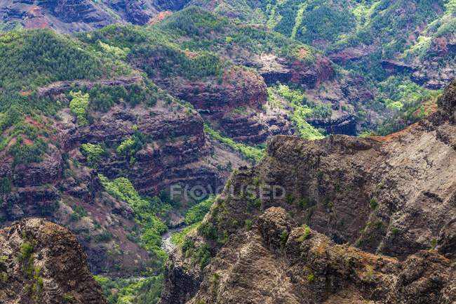 Elevated view of deep canyons, green fertile valleys and steep peaks of an island landscape — Stock Photo