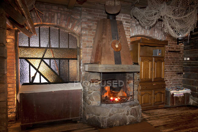 Ein Hotel mit altmodischen Zimmern im Retro-Stil und rustikalen Objekten, offenem Feuer mit großem gemauerten Kamin und Holzboden — Stockfoto