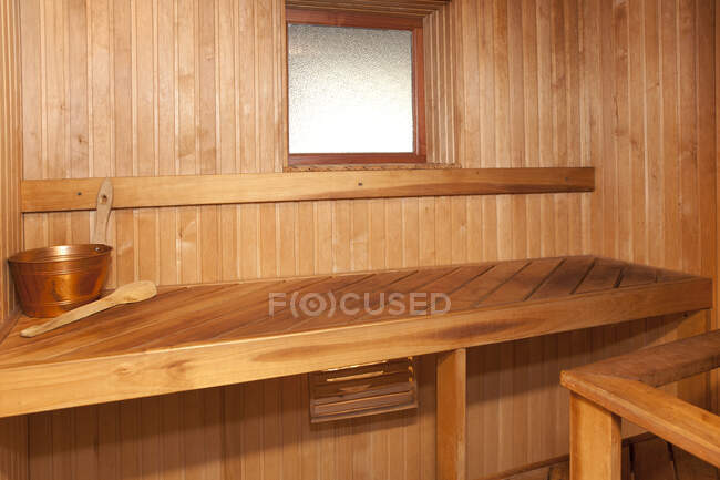 Interior de la sauna del spa vacío, paredes revestidas de madera y asientos. - foto de stock