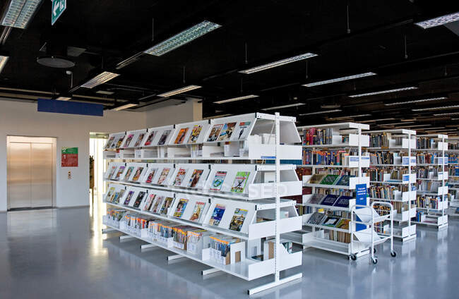 Public library, modern interior with shelves of books — Stock Photo