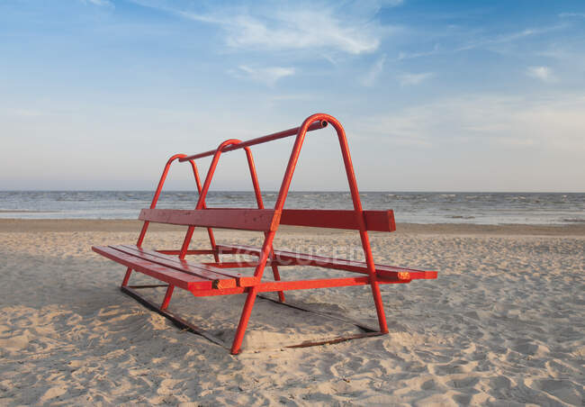 Banco do parque vermelho na praia — Fotografia de Stock
