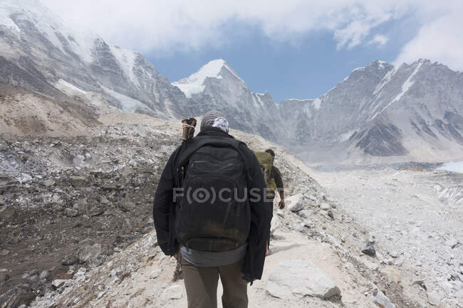 Dois alpinistas caminhando ao longo de um caminho nas montanhas — Fotografia de Stock