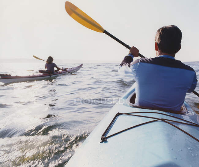 Middle aged man and woman sea kayaking on calm waters — Stock Photo