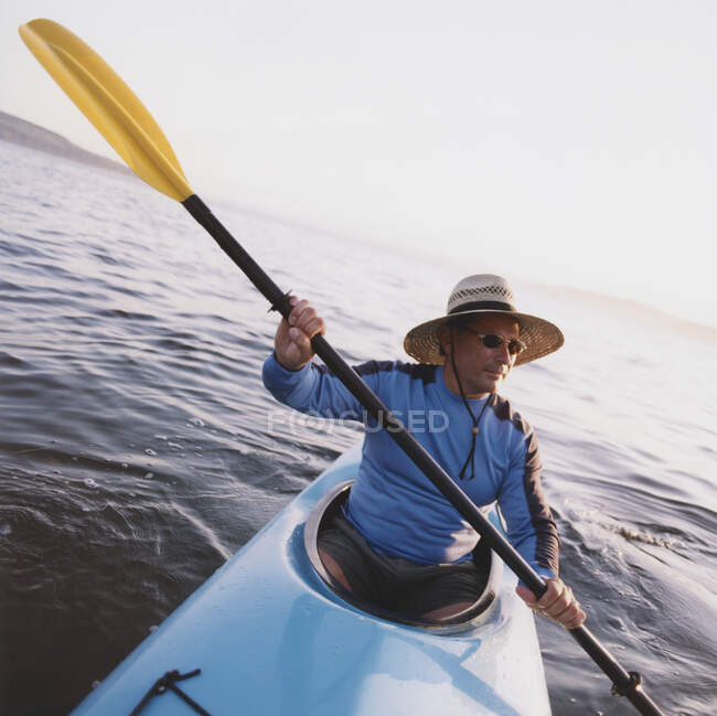 Hombre kayak de mar al atardecer - foto de stock