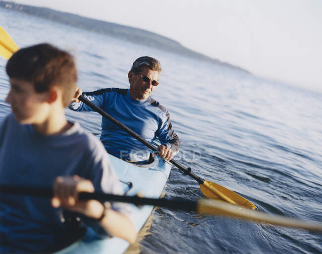 Padre e hijo remando en kayak de mar - foto de stock