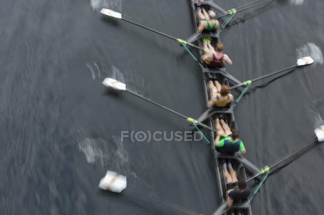 Overhead view of a crew rowing in a four on the surface of a lake. — Stock Photo