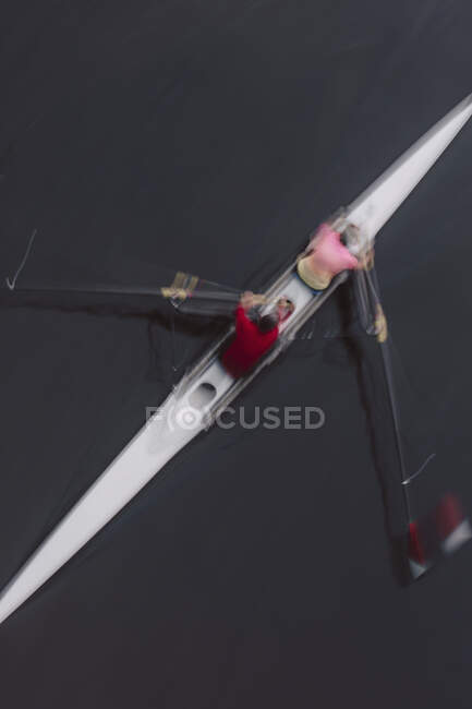 Vue aérienne de deux personnes ramant dans un canot, une paire dans un bateau — Photo de stock