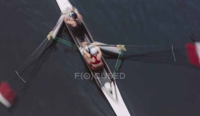 Overhead view of two people rowing in a scull, a pair in a boat — Stock Photo