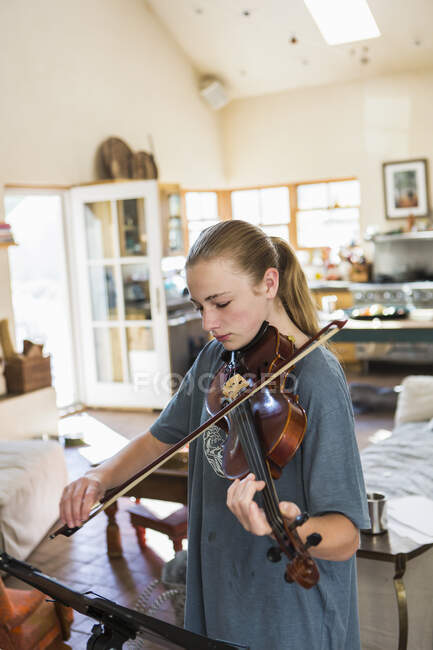 Девочка-подросток играет на скрипке дома — стоковое фото