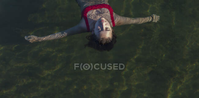Swimmer floating on the surface of calm water. — Stock Photo