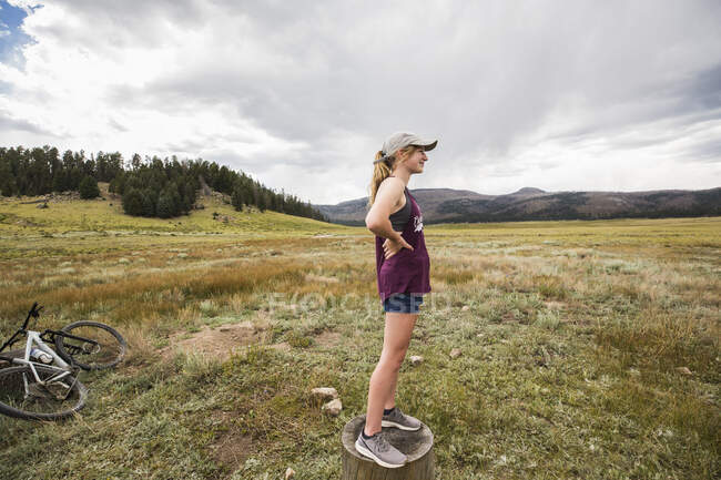 Teenage girl standing on stump — Stock Photo