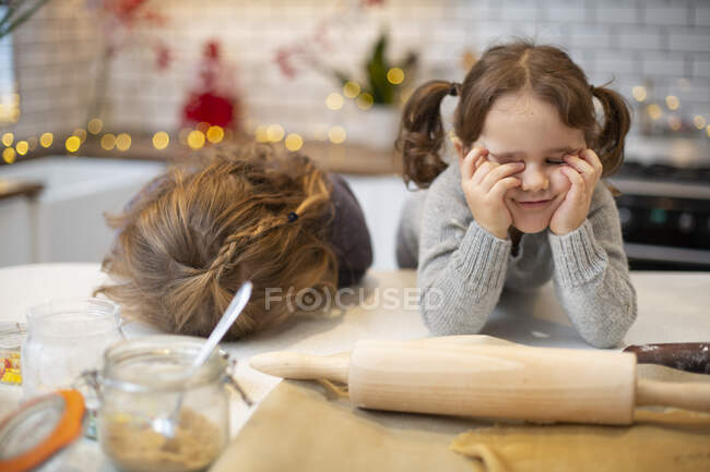 Duas meninas de pé na cozinha, fazendo biscoitos de Natal. — Fotografia de Stock